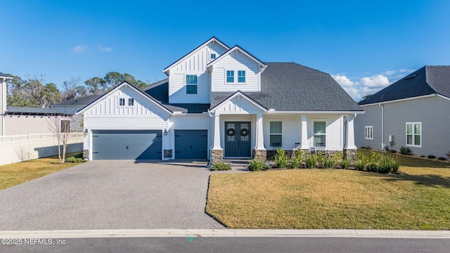 view of front of house with a porch, a garage, and a front lawn