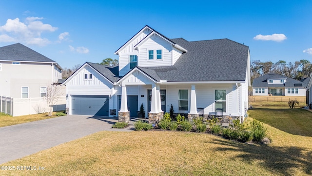 view of front of property featuring a garage, a front yard, and covered porch