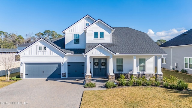 view of front of property with a porch, a garage, and a front yard