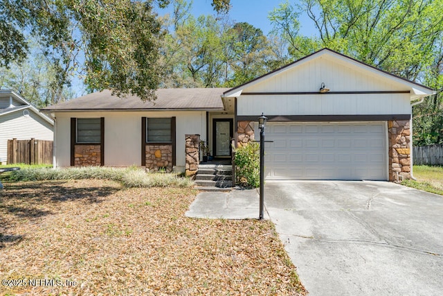 single story home with stone siding, driveway, an attached garage, and fence