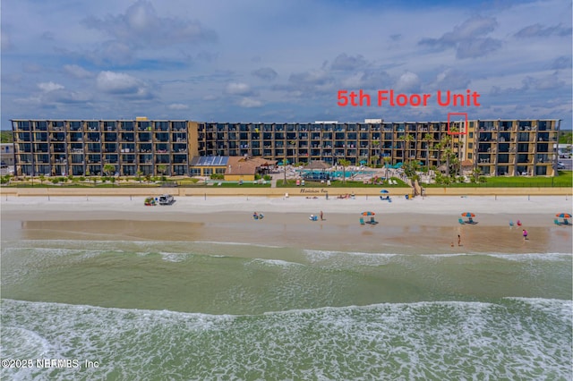 drone / aerial view featuring a water view and a beach view