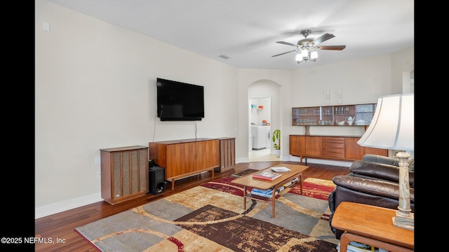 living room with ceiling fan, dark hardwood / wood-style flooring, and washer / dryer