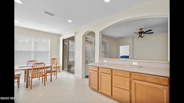 kitchen featuring light tile patterned flooring, ceiling fan, and a textured ceiling