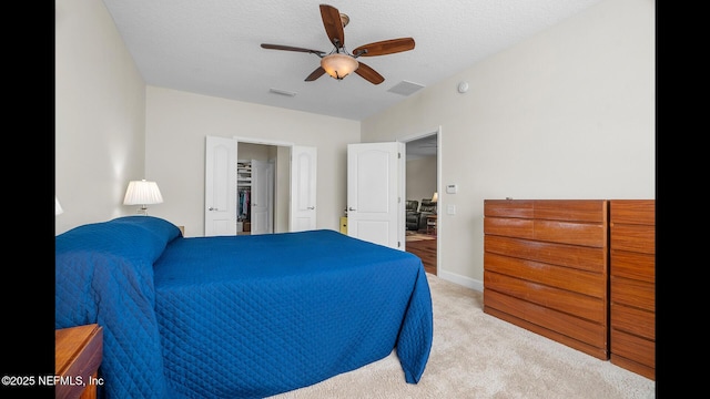 bedroom featuring light carpet, a textured ceiling, and ceiling fan