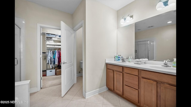 bathroom featuring tile patterned flooring, vanity, and a shower with door