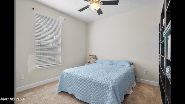 bedroom featuring light colored carpet, a textured ceiling, and ceiling fan