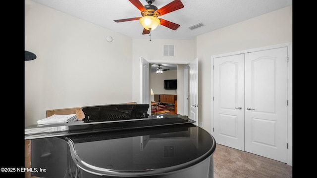 interior space with ceiling fan and light colored carpet