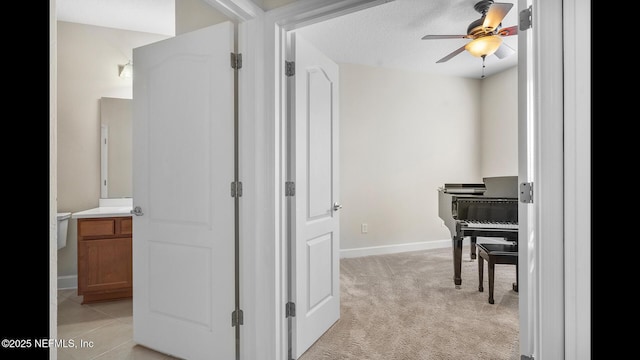 hallway with light carpet and a textured ceiling