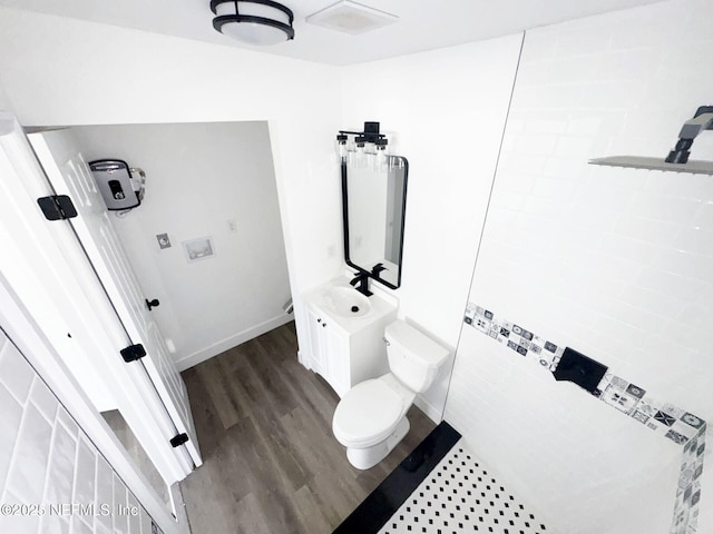 bathroom with wood-type flooring, vanity, and toilet