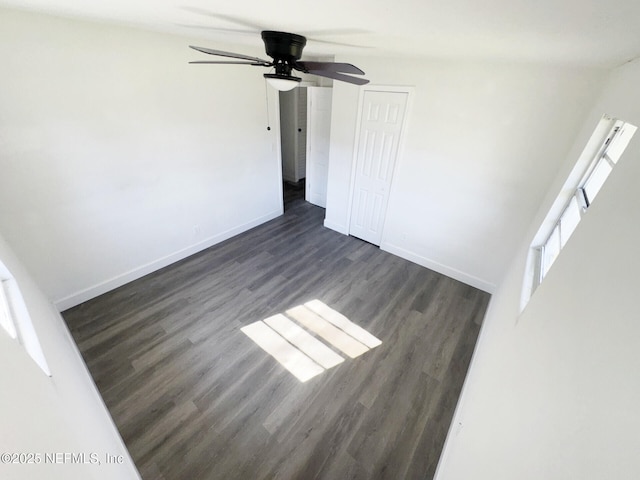 spare room with dark hardwood / wood-style floors and ceiling fan