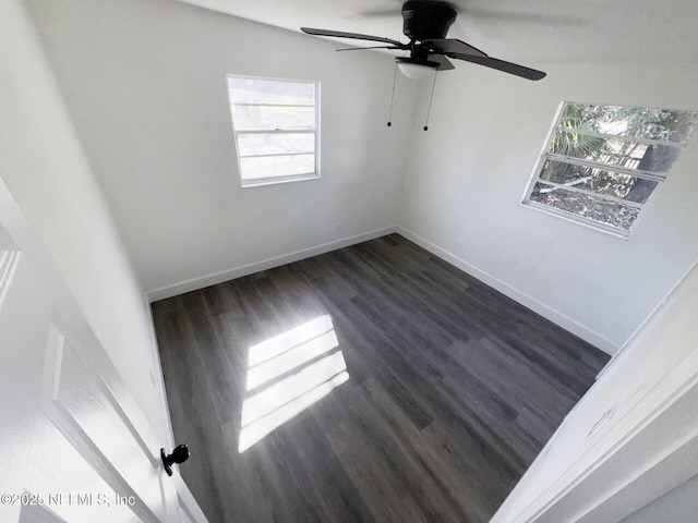 spare room with dark wood-type flooring and ceiling fan