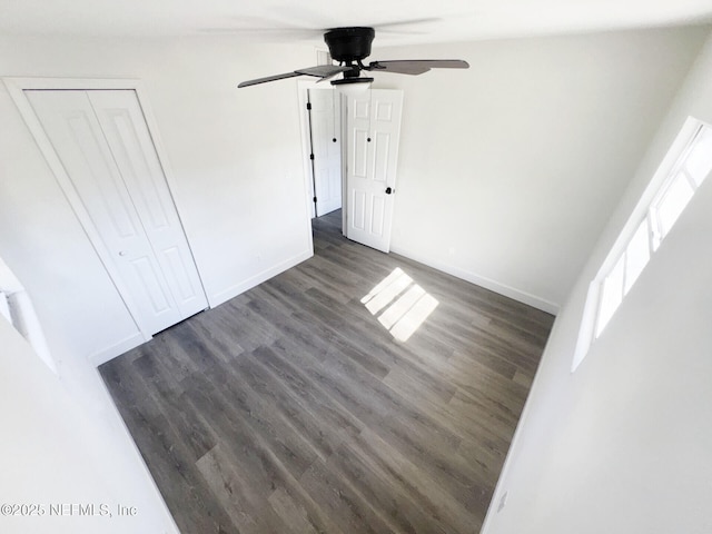 unfurnished bedroom with a closet, dark hardwood / wood-style floors, and ceiling fan