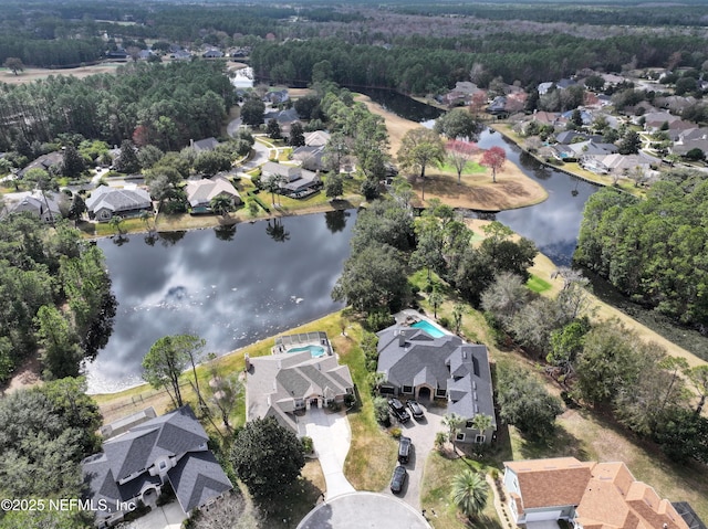 drone / aerial view featuring a residential view, a view of trees, and a water view