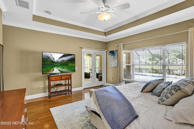 bedroom with french doors, visible vents, crown molding, wood finished floors, and access to outside