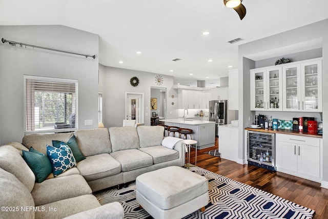 living area featuring bar, visible vents, dark wood-style floors, beverage cooler, and recessed lighting