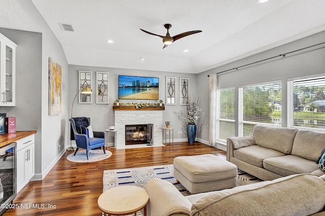 living room featuring beverage cooler, ceiling fan, visible vents, and wood finished floors