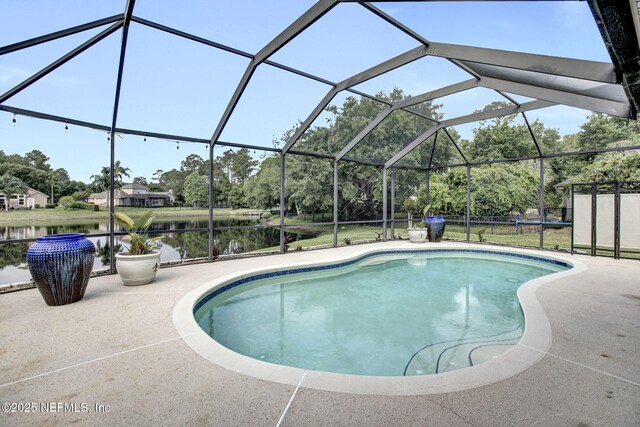 pool with glass enclosure, a water view, and a patio