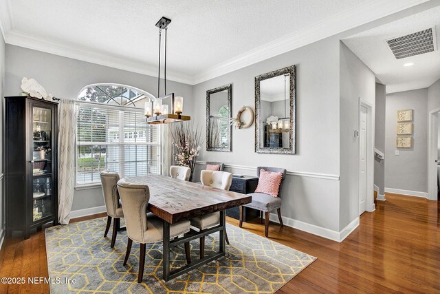 dining space with baseboards, visible vents, and wood finished floors