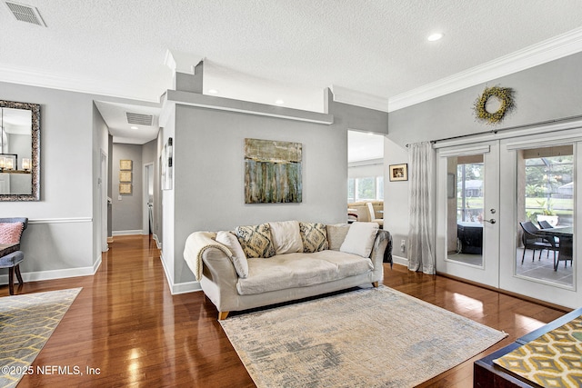 living area with crown molding, french doors, a textured ceiling, and visible vents