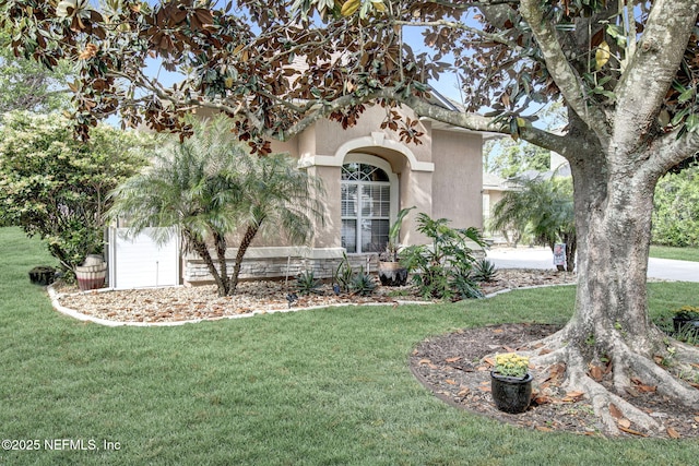 view of front of property featuring stucco siding and a front yard