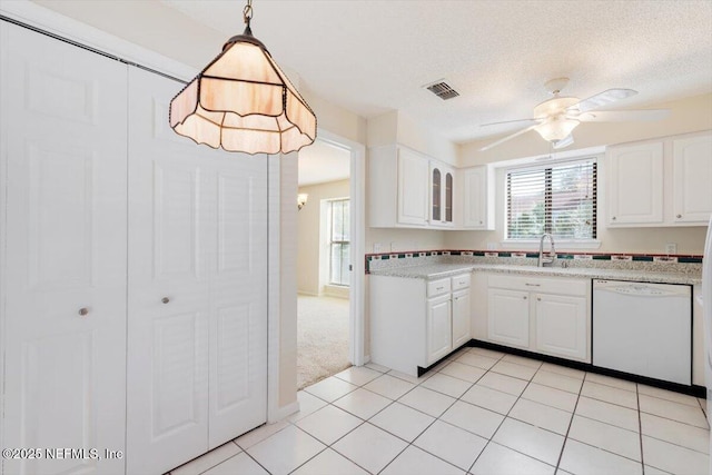 1706 Wood Hill Pl Unit 1706, Jacksonville, FL 32256 - kitchen with white dishwasher, visible vents, pendant lighting, white cabinetry, and glass insert cabinets