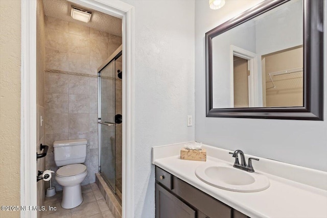 1706 Wood Hill Pl Unit 1706, Jacksonville, FL 32256 - bathroom featuring a textured wall, vanity, a shower stall, toilet, and tile patterned flooring