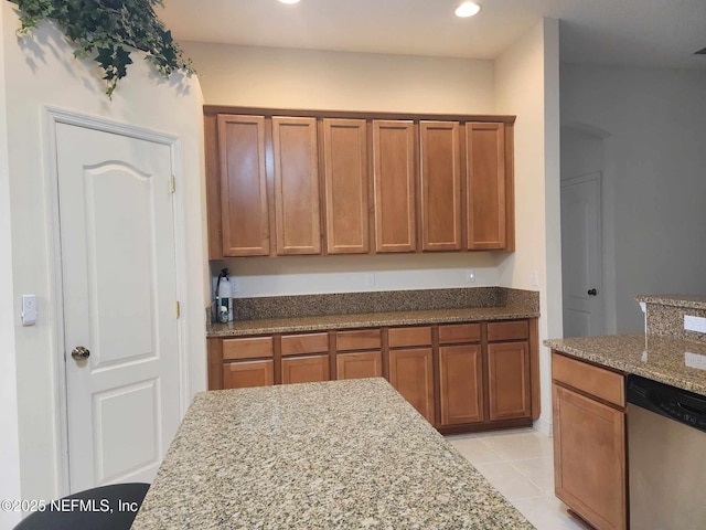 kitchen featuring light stone counters, stainless steel dishwasher, and light tile patterned flooring