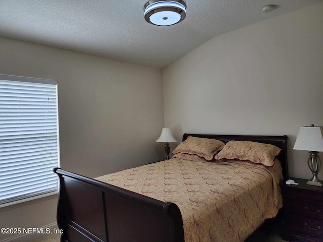 bedroom with lofted ceiling and a textured ceiling