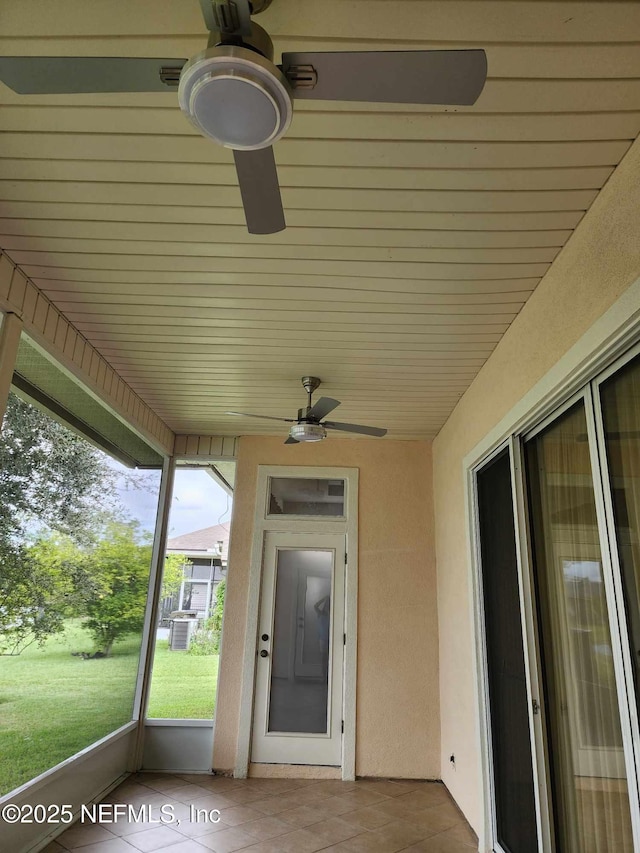 unfurnished sunroom with ceiling fan