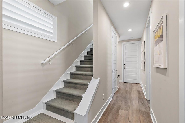 staircase featuring recessed lighting, wood finished floors, and baseboards