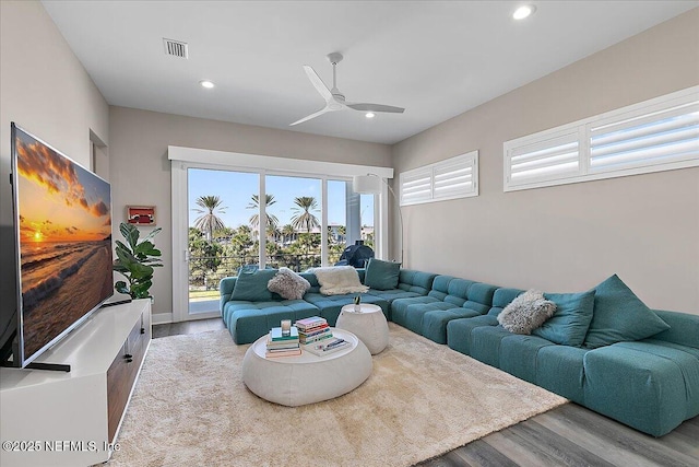 living room featuring light wood-type flooring, visible vents, ceiling fan, and recessed lighting