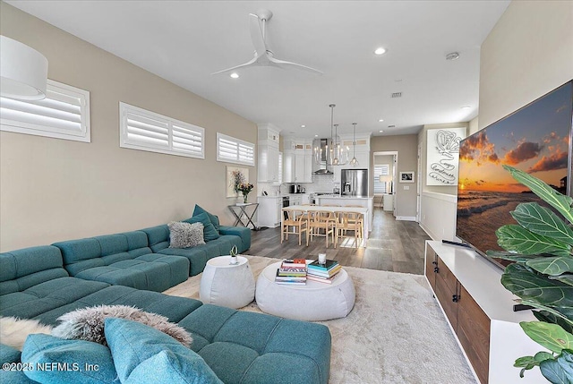 living area with ceiling fan, dark wood-style flooring, visible vents, and recessed lighting