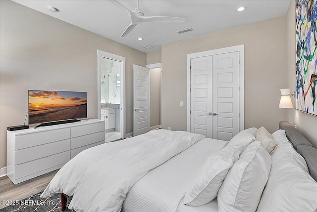 bedroom with light wood-type flooring, visible vents, a closet, and recessed lighting