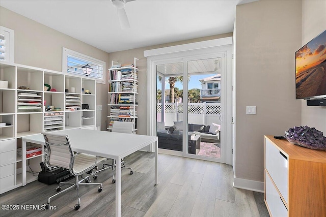 office space with light wood-type flooring and baseboards