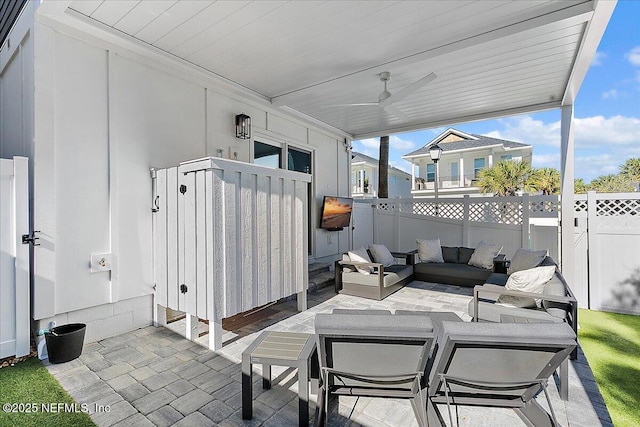 view of patio featuring ceiling fan, fence, and an outdoor living space