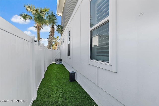 view of home's exterior with fence and a lawn