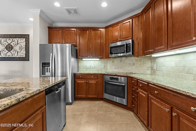 kitchen with brown cabinets, stainless steel appliances, visible vents, backsplash, and light stone countertops