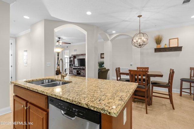 kitchen with arched walkways, brown cabinets, a kitchen island with sink, stainless steel dishwasher, and a sink