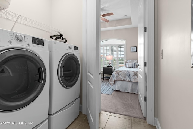 clothes washing area featuring light tile patterned floors, laundry area, washing machine and clothes dryer, and a ceiling fan