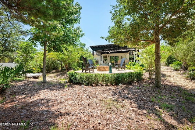 view of yard with an outdoor fire pit, a pergola, and a patio area