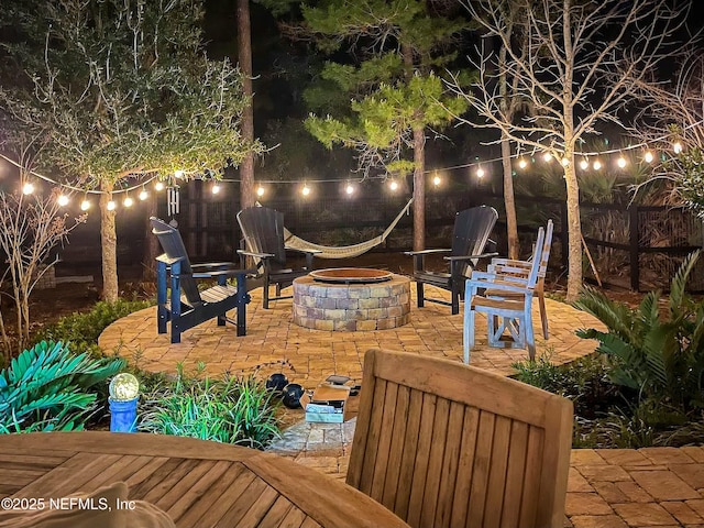 patio at night featuring a fire pit