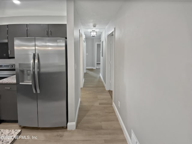 kitchen featuring gray cabinets, stainless steel refrigerator with ice dispenser, stove, and light hardwood / wood-style flooring