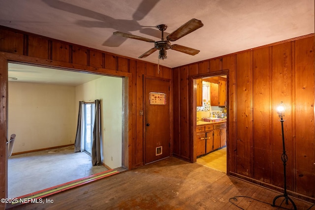 corridor with wooden walls and light hardwood / wood-style floors