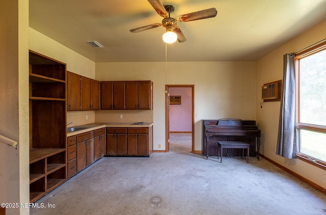 kitchen with an AC wall unit, sink, a wealth of natural light, and ceiling fan