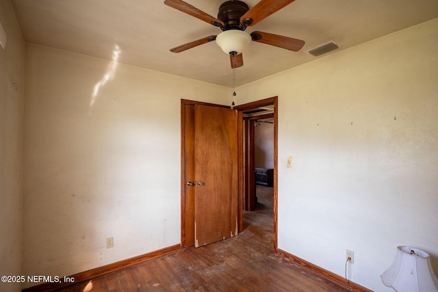 empty room with dark hardwood / wood-style floors and ceiling fan