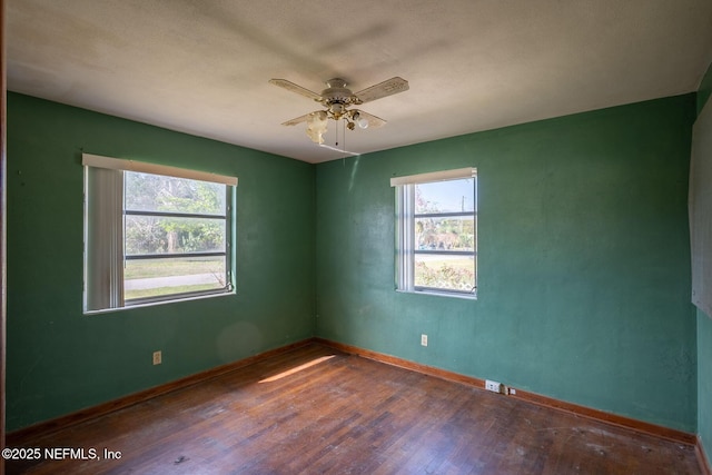 unfurnished room with dark hardwood / wood-style flooring and ceiling fan