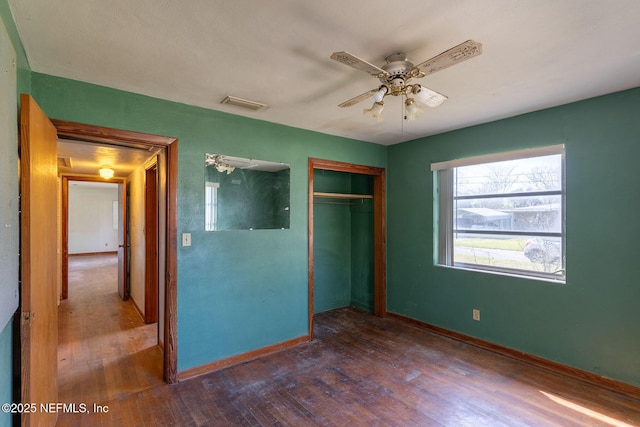 unfurnished bedroom with ceiling fan, dark hardwood / wood-style floors, and a closet