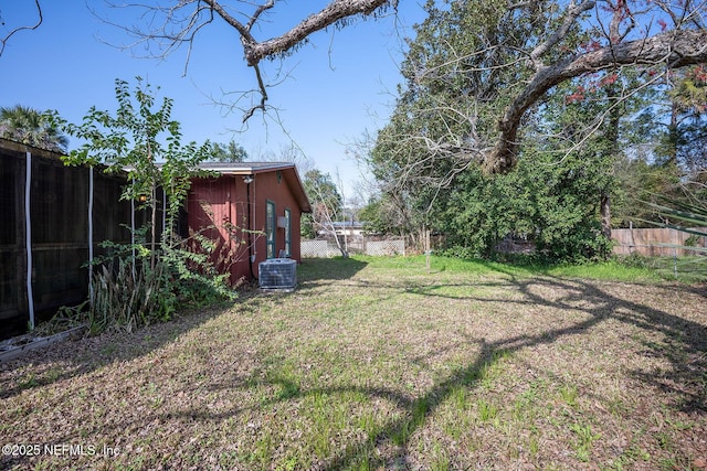 view of yard with central AC and a storage unit