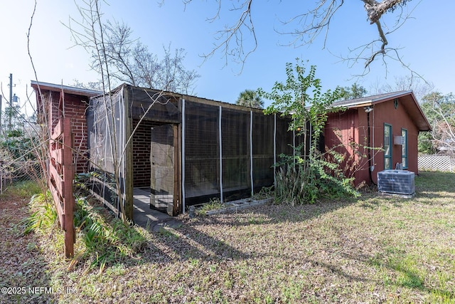 rear view of house with a yard, an outdoor structure, and central air condition unit