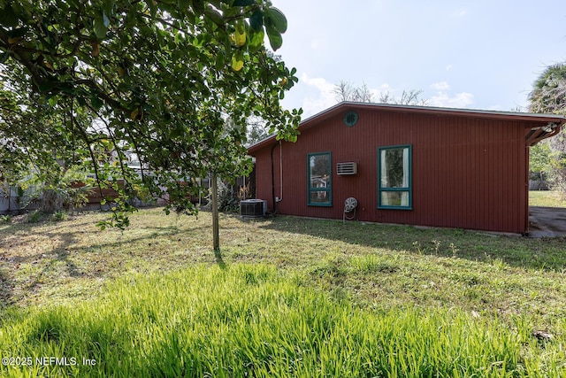 view of side of home with a yard and central air condition unit